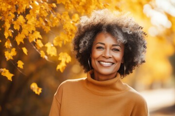 Portrait of a tender afro-american woman in her 60s wearing a sporty polo shirt against a background of autumn leaves. AI Generation