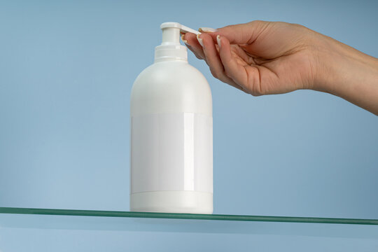 Hand dispensing lotion from a white pump bottle