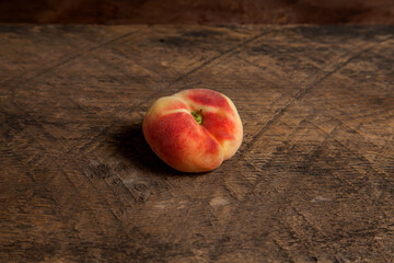 Saturn peach or flat peach on wooden background..