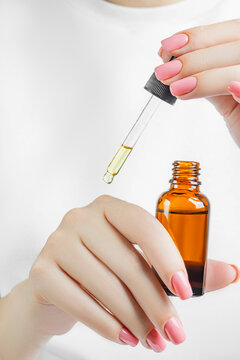 Woman applying nail oil for cuticle care