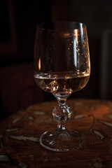 Gold wedding rings on a brown background. Gold wedding rings in a glass of champagne