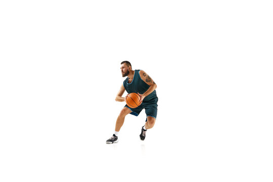 Basketball professional in uniform, exhibiting flawless dribbling technique and executing impressive slam dunk against white background.