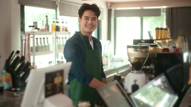 An Asian man entrepreneur or barista working in modern coffee shop , concept small business