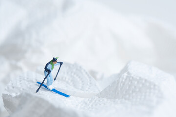 Skiers in action, white snow landscape, miniature figures scene, winter sports