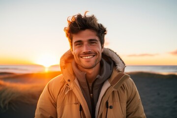 Portrait of a cheerful man in his 20s wearing a warm parka against a beautiful beach sunset. AI Generation