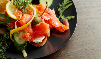 Smoked salmon with dill, cucumber, capers, green onion, and lemon.