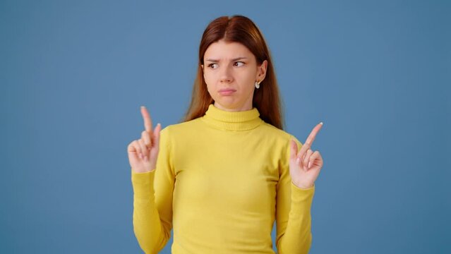 Displeased young lady shows refuse gestures on blue background