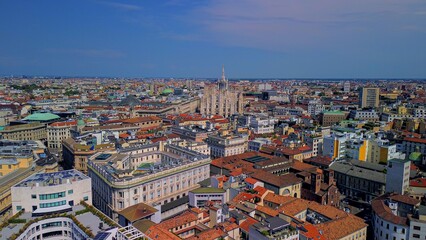 Aerial view of Piazza Duomo in front of the gothic cathedral in the center. Drone view of the gallery and rooftops during the day. Flight over the city. People in the city. Milan. Italy 15.12.2023