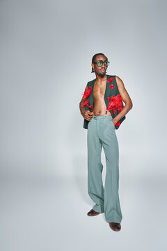appealing african american man in stylish vest with red tulle fabric looking away, fashion concept