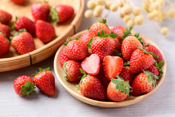 Fresh strawberry fruit in wooden bowl on white background