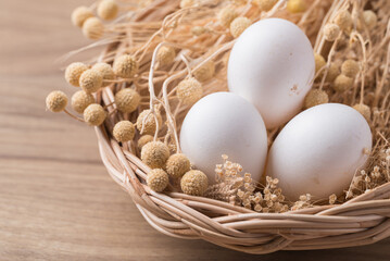 Organic white leghorn egg from free range farm in basket on wooden table - obrazy, fototapety, plakaty