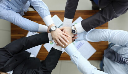 Top view of business colleagues put hands together. Conference room with executive manager...