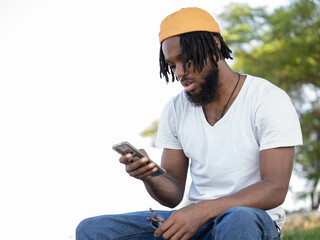 Black man messaging on smartphone in park