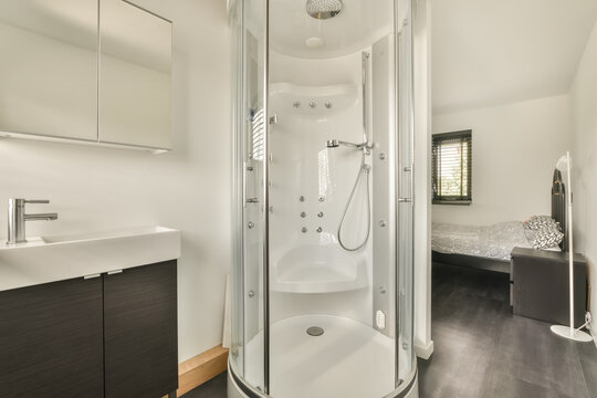 Modern bathroom with glass shower and bedroom view