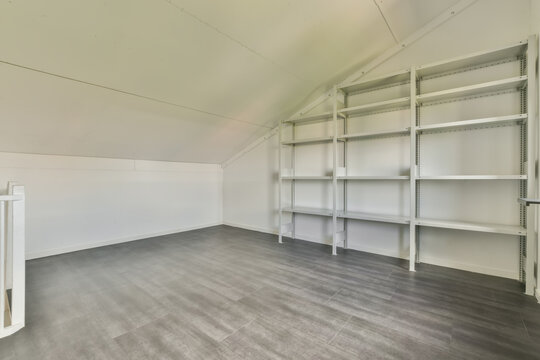 Empty attic room with metal storage shelves