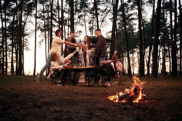 Obraz premium Beautiful bonfire at evening time. Group of friends are together in the forest