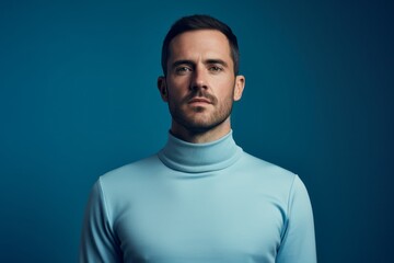 Obraz premium Portrait of a content man in his 30s showing off a thermal merino wool top against a soft blue background. AI Generation