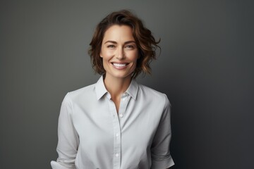 Portrait of a content woman in her 40s wearing a simple cotton shirt against a soft gray background. AI Generation