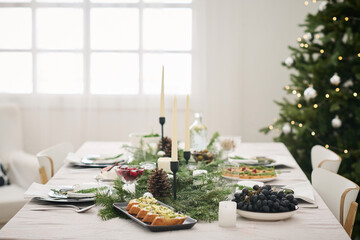 Medium shot of christmas table with appetizers and fruits fully arranged for festive dinner