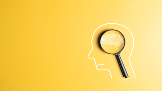Human head with brain icon inside magnifier on yellow background. Creative idea thinking, Awareness of Alzheimer's, Parkinson's, neurology, brain diseases cognitive problems, and psychology care.