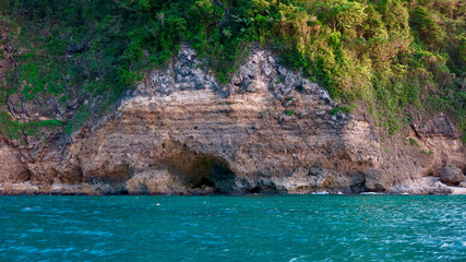 A section of rock near the water. Rocky cliff of a tropical island by the sea.