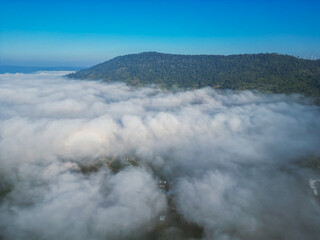 Fototapeta na wymiar Aerial view of flowing fog waves on mountain tropical rainforest.Khao Kho, Phetchabun, Thailand.