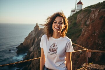 Portrait of a joyful woman in her 20s sporting a vintage band t-shirt against a majestic lighthouse on a cliff background. AI Generation - obrazy, fototapety, plakaty