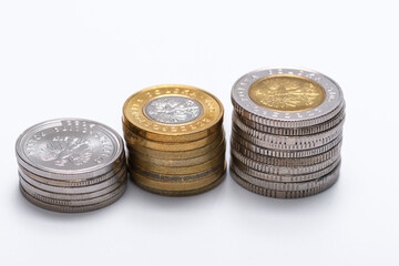 Stos monet w polskiej walucie leży na białym tle