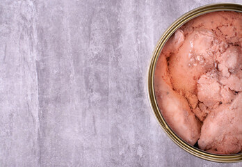 Canned cod liver in open metal tin with oil on the gray table. Copy space - obrazy, fototapety, plakaty