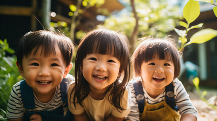 日本の幼稚園児3人が私服で横に並んで笑っている写真、背景自然の森、森のようちえん - obrazy, fototapety, plakaty