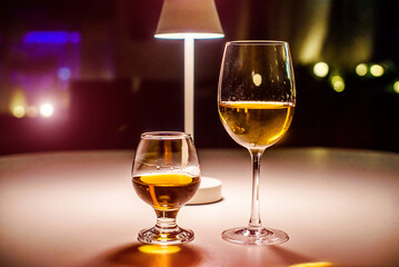 Glasses of white wine and cognac are on the table in the restaurant
