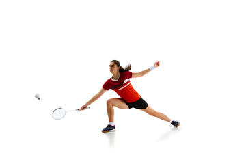 Fototapeta na wymiar Intensity of championship preparation. Badminton athlete demonstrates her skills in attack and defense against white background. Concept of sport, active lifestyle, strength, power, action. Copy space