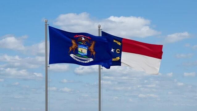 North Carolina and Michigan US state flags waving together on cloudy sky, endless seamless loop