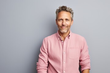 Obraz premium Portrait of a content man in his 40s wearing a comfy flannel shirt against a pastel or soft colors background. AI Generation