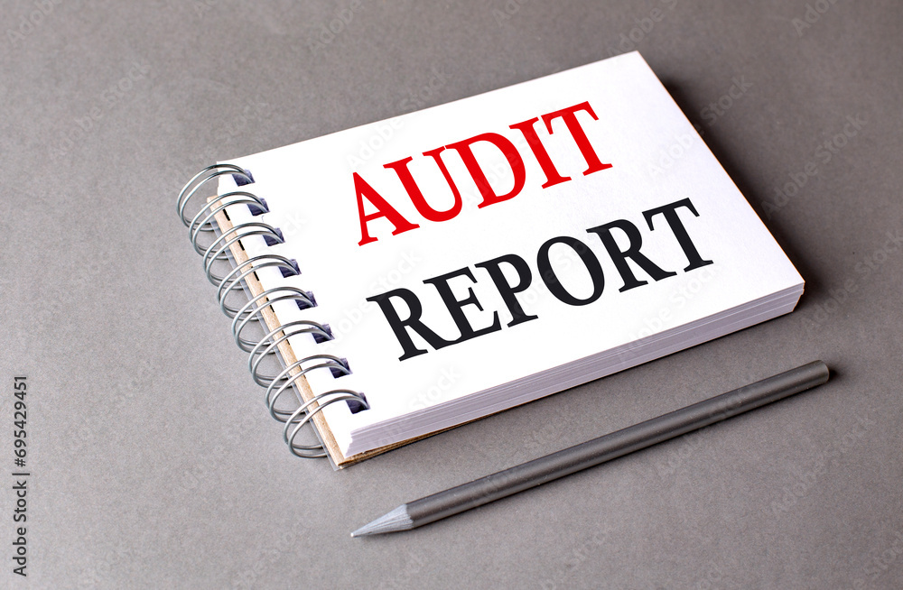 Aufkleber audit report word on notebook on grey background
