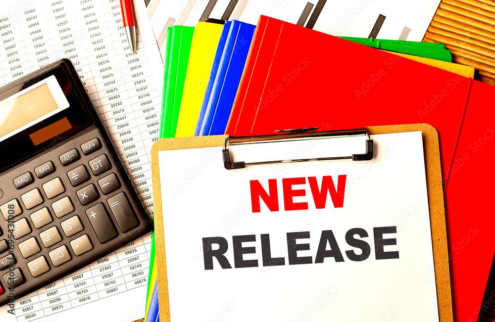 Poster new release text written on paper clipboard with chart and calculator