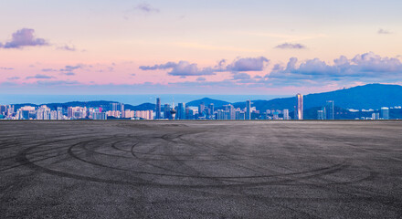 Asphalt road square and city skyline with mountain landscape at sunset in Zhuhai, China. Panoramic...