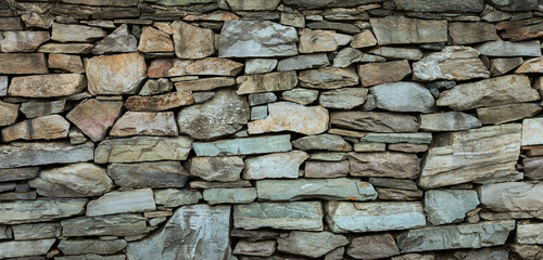 textured stone wall, showcasing rugged surface and natural patterns