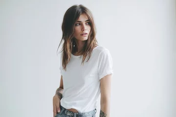 Fotobehang jeune femme en t-shirt blanc et jeans contre un mur blanc © Sébastien Jouve