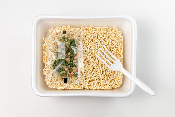 instant noodles with seasoning and a fork