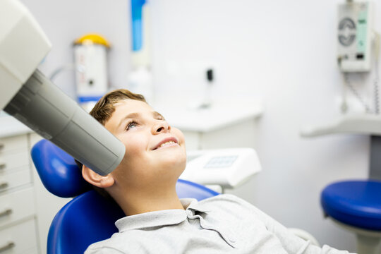 A Caucasian boy between 9 and 10 years old visits a dental clinic to have an intraoral x-ray to identify cases of cavities, intraoral x-ray concept. Tooth care in the little ones.