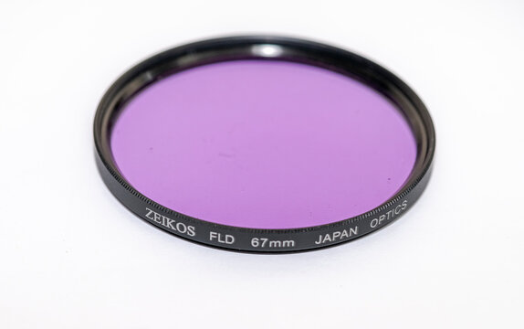 Algeria - March 27, 2023: A 67mm ZEIKOS FLD "fluorescent light day" filter for dslr photography camera. Japan optics equipment set up isolated on white background macrophotography studio shot