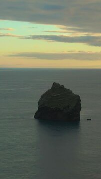 Cliff in Sea at Sunset. Reykjanes Peninsula. Iceland. Aerial View. Drone is Orbiting. Vertical Video