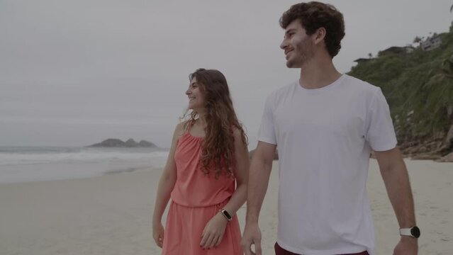 Casal conversando, caminhando pela praia. Cinematico 4k.