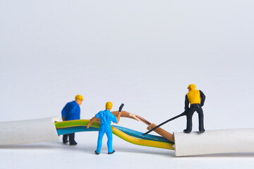 Repairing a broken power cable, miniature figures scene, white background