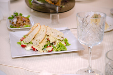 Egg, tomato, ham and bruschetta salad on a festive table with food, drinks, dishes and utensils