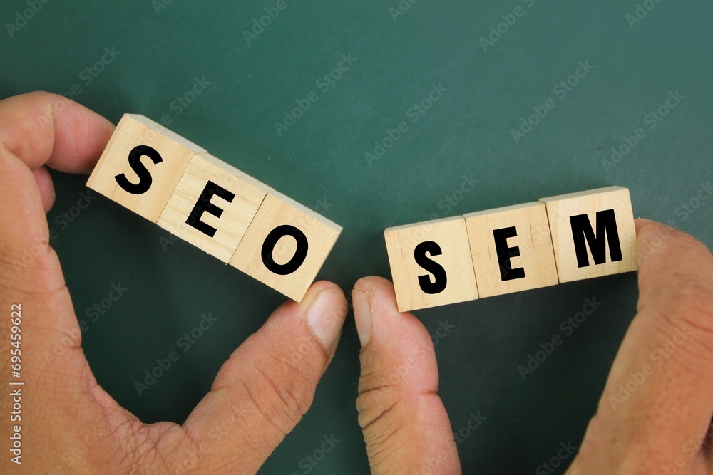 Poster hand holding a wooden cube with the letters sem and seo. concept for search engine optimization and 