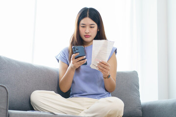 Obraz premium Asian woman holding paper document calculating money savings paying bills in mobile application using smart phone payment online with paying household bills tax insurance managing budget.