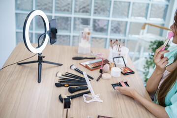 Beauty influencer Asian girl makeup artist applying powder foundation by brush. Beauty influencer...