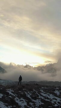 Ama Dablam Mountain and Hiker Man at Sunset. Himalaya, Nepal. Aerial View. Drone is Orbiting. Vertical Video
